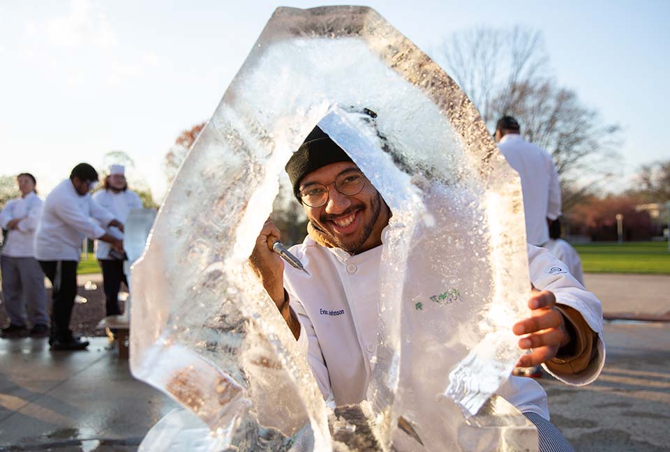 Evan Johnson peering through an ice sculpture